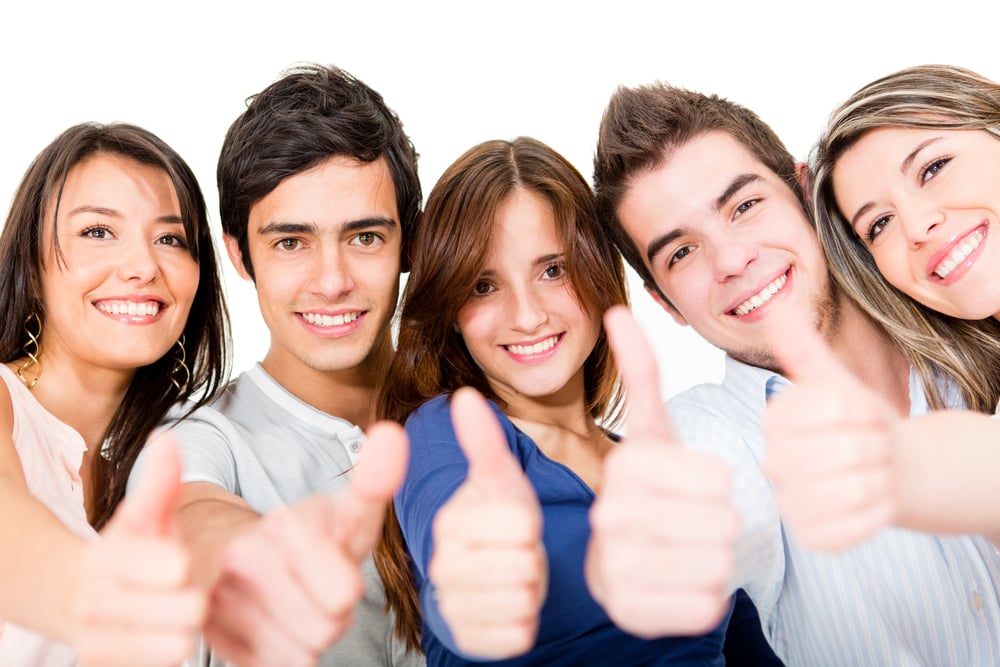 Group of young people with thumbs up - isolated over a white background